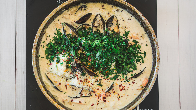 seafood pasta sauce in pot topped with parsley