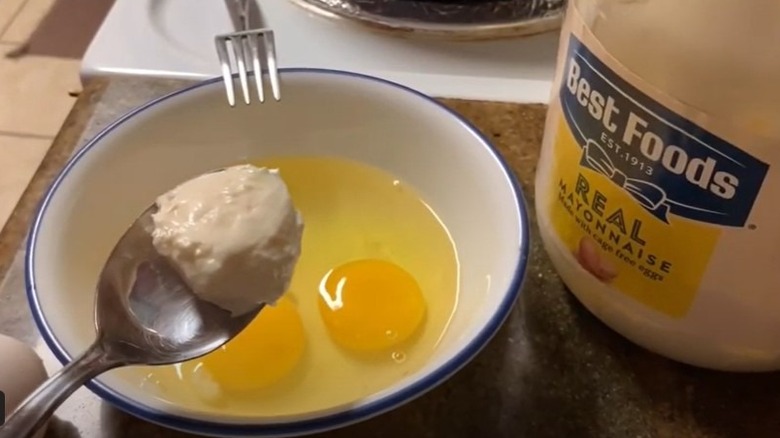 Eggs in bowl with spoon of mayonnaise and pot