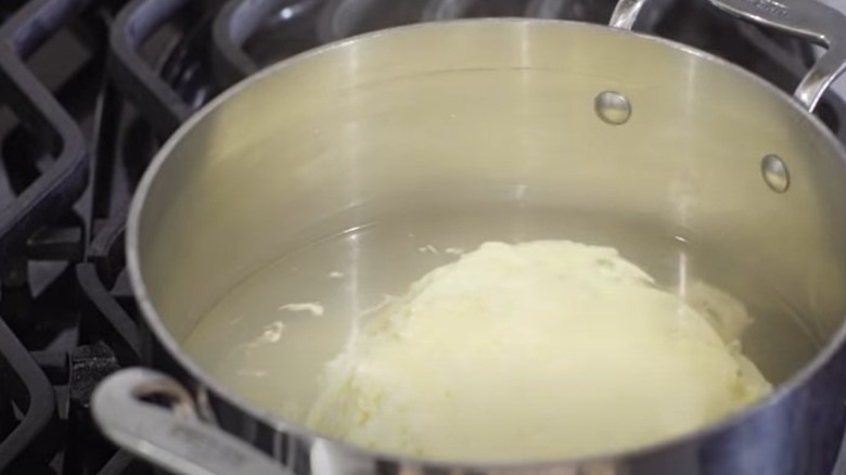 Scrambled eggs cooking in water in a pan