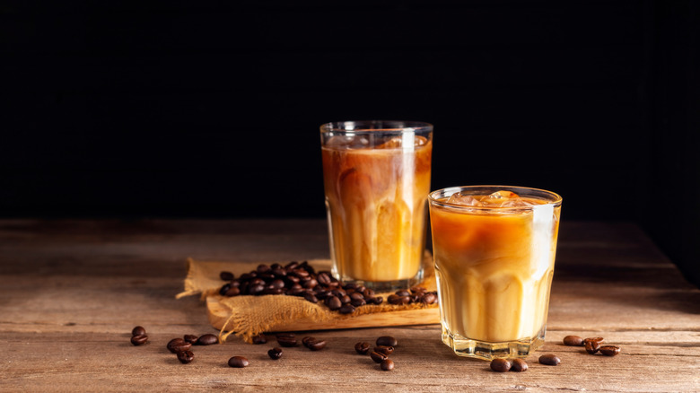 Milky coffee cocktails in two glasses with coffee beans