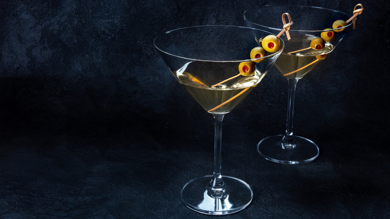 Two dirty martinis on a black background