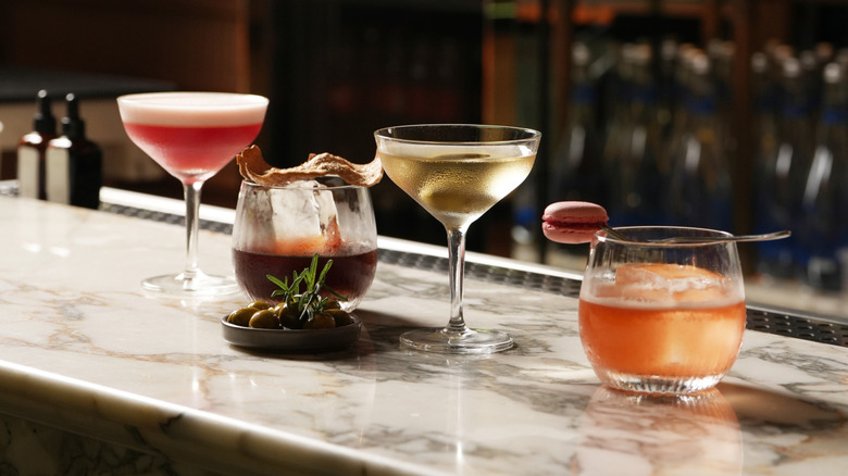 Four different cocktails on a marble bar