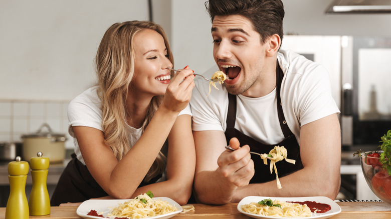 couple feeding each other spaghetti