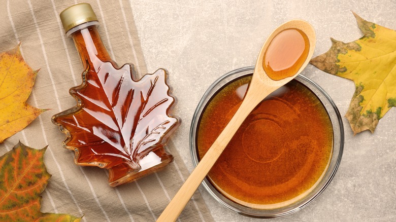 Bowl of maple syrup next to bottle of maple syrup