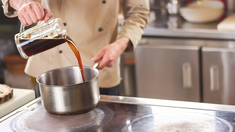 Person pouring beer into saucepan