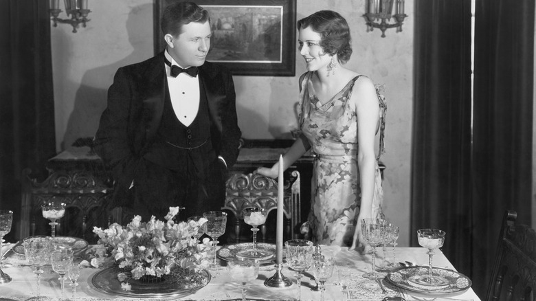 Formal couple standing at fancy table