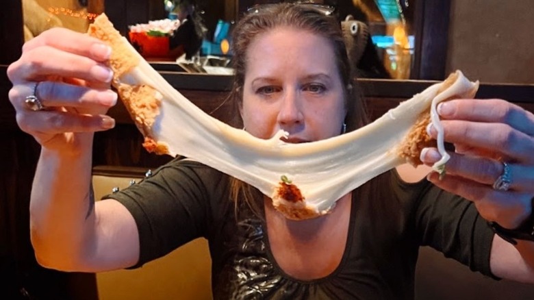 woman pulling large mozzarella stick