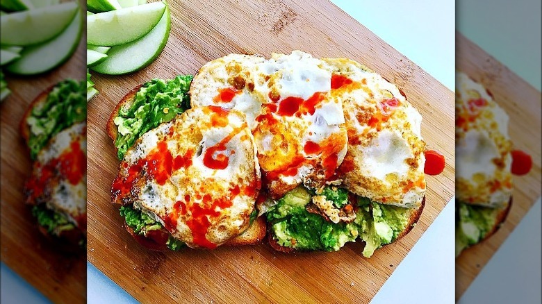 pesto toast with eggs drizzled with hot sauce