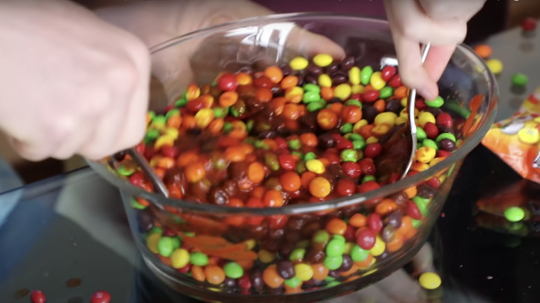 mixing a bowl of skittles and hot sauce