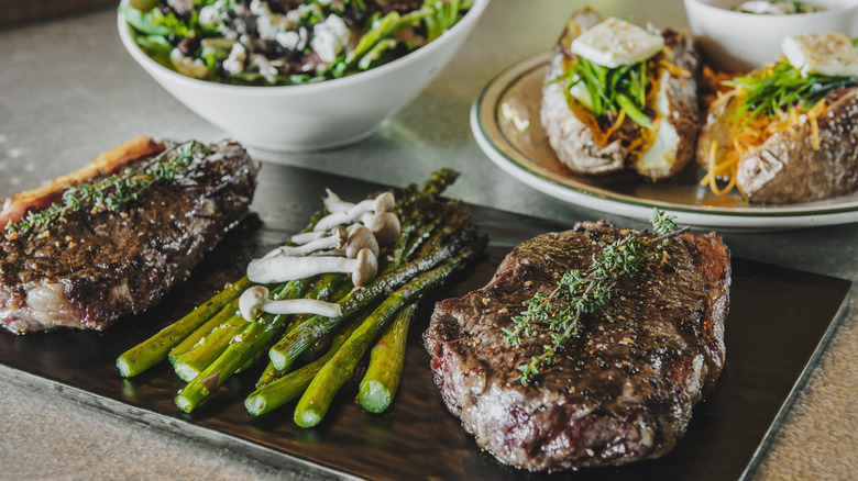 Steak and asparagus with salad and baked potatoes