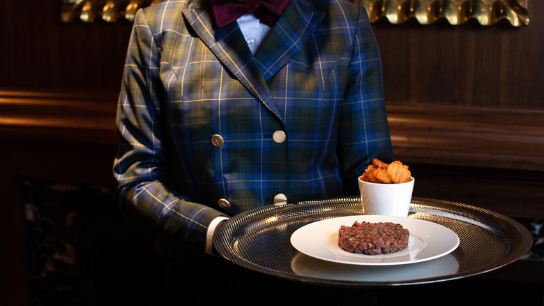 Server with tray of beef tartare 