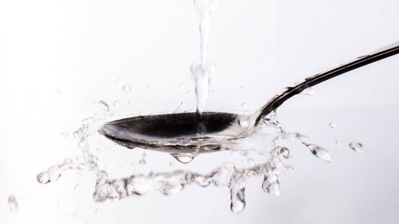 Water splashing on a metal spoon