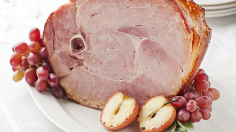 Cooked bone-in ham with apples and grapes