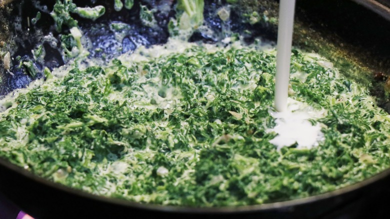 Dairy poured into creamed spinach pan