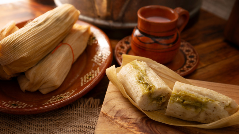 Unwrapped tamale and pile of wrapped tamales