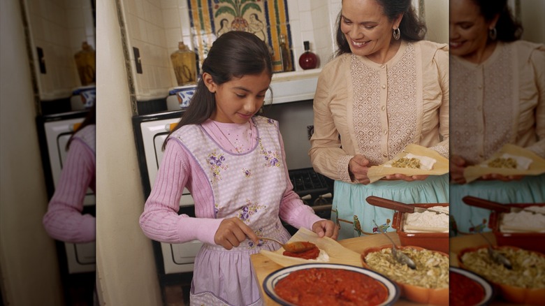 A family adding fillings to tamales