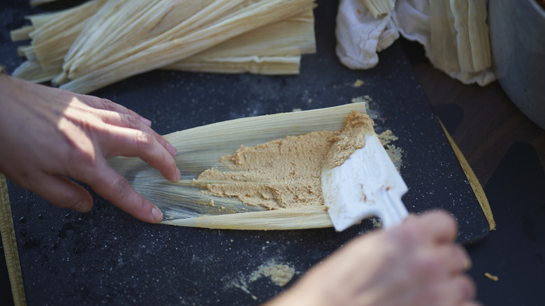 Spreading masa on corn husks