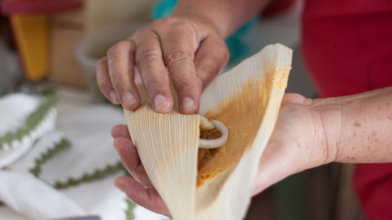 Hands wrapping tamales