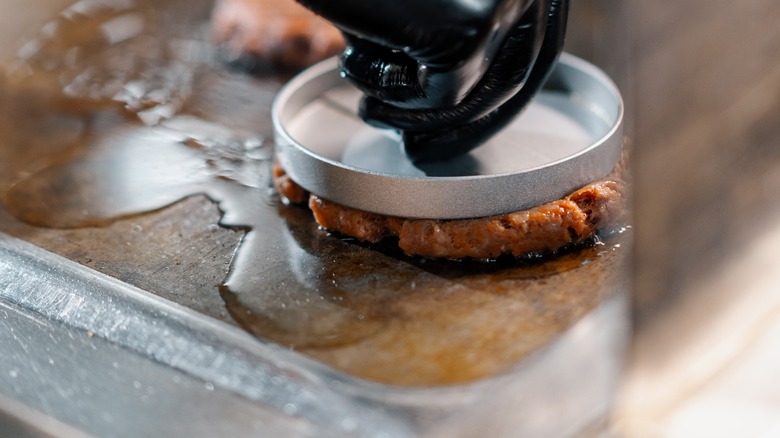 Press on smash burger on griddle