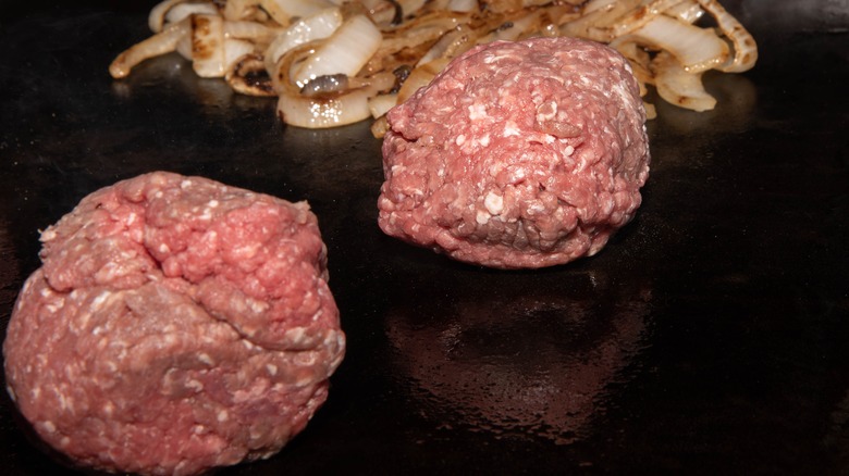 Meatball parries on a griddle with fried onions