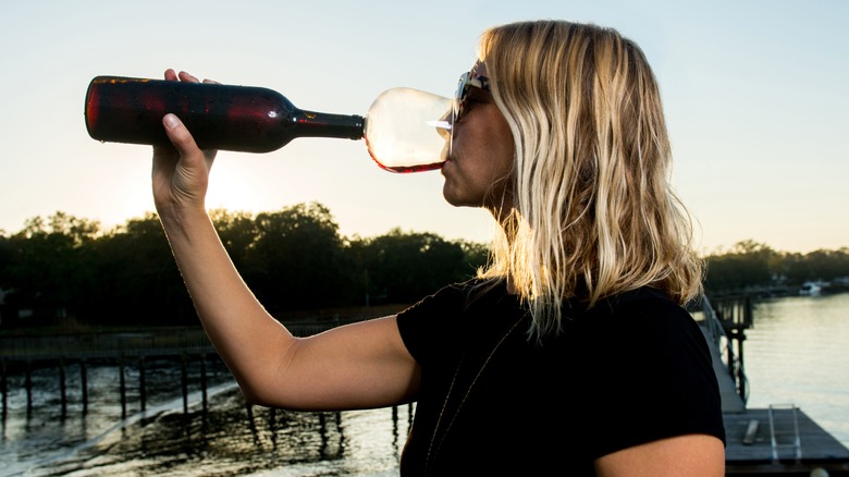 Woman drinking wine from the bottle with a Guzzle Buddy