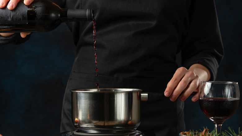 Pouring red wine into pot