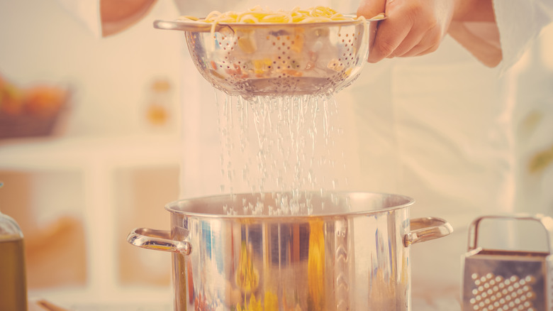 Draining spaghetti into pot