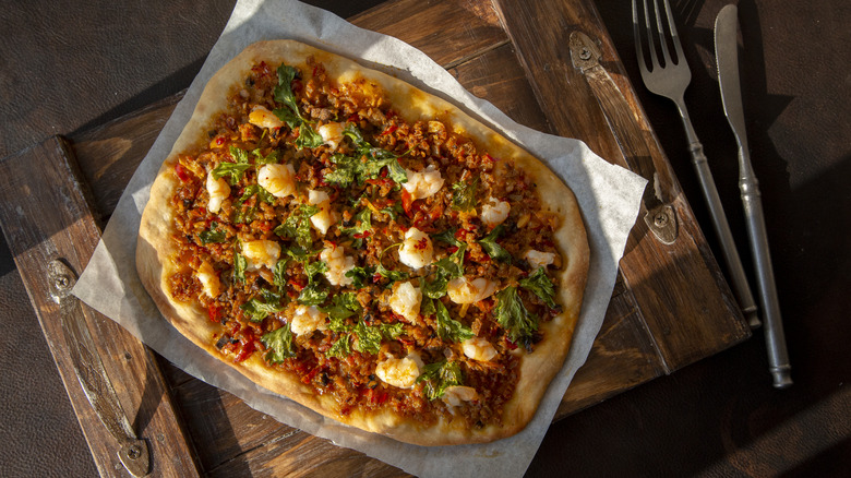 harissa pizza on paper with utensils