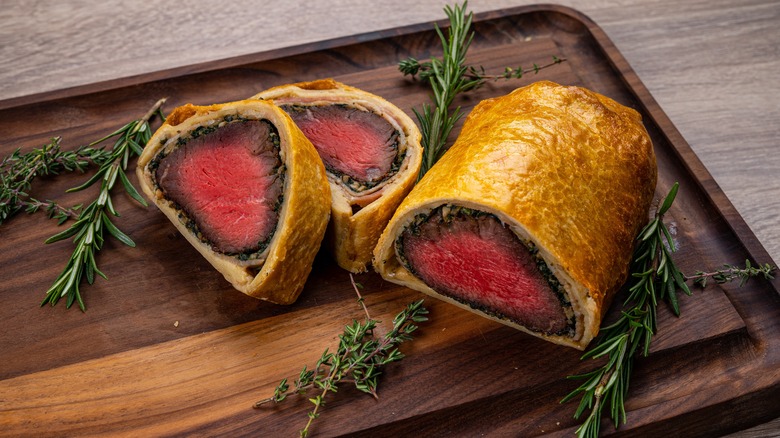 Beef Wellington sliced on cutting board