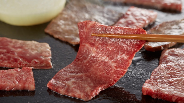 Chopsticks holding yakiniku steak