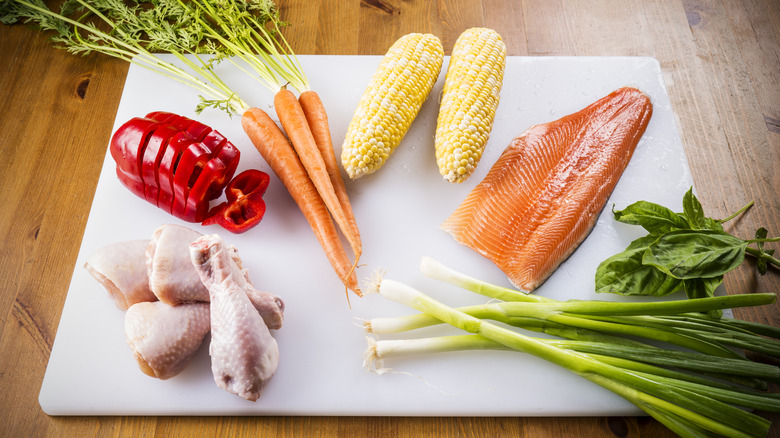 Raw meat and vegetables on a cutting board