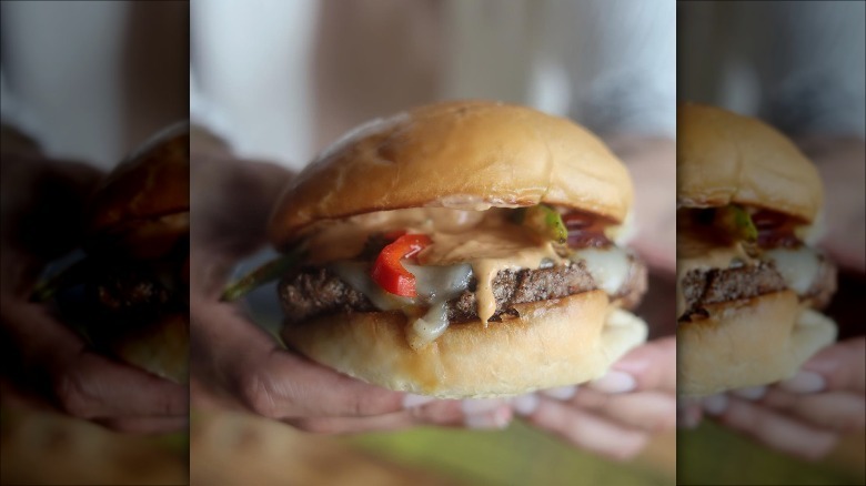 man holding Fuddruckers burger