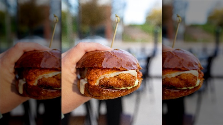 man holding burger from Hopdoddy