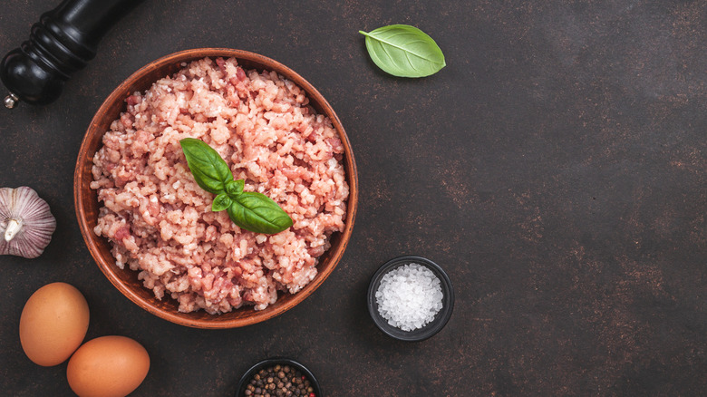 raw ground pork in bowl with seasonings