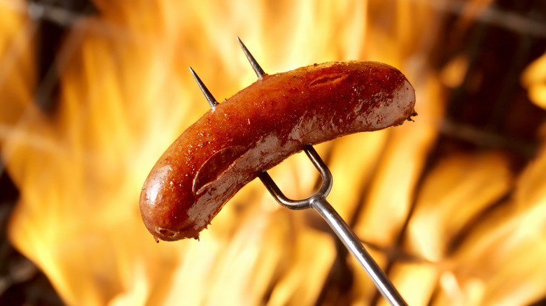 Sausage on pitchfork over flame