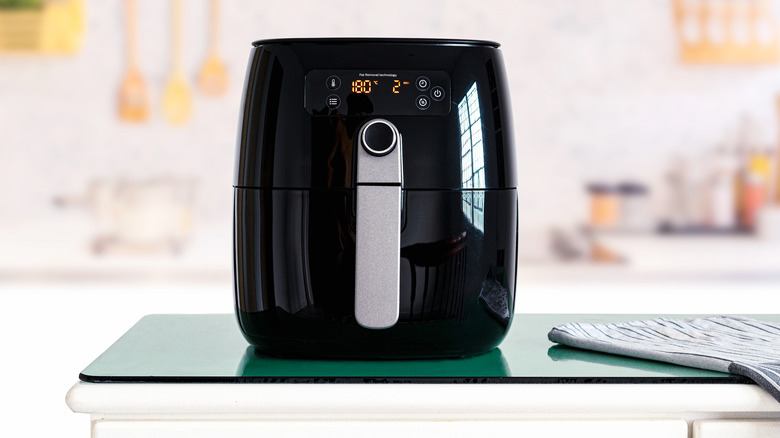 Black air fryer on green counter