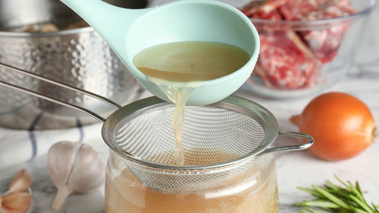 straining broth into jar