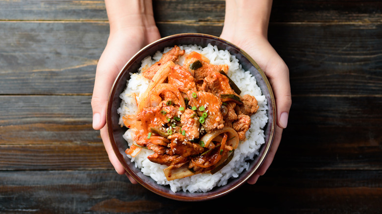 Holding bowl of rice stir-fry