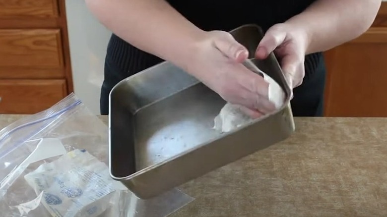 greasing cake pan with butter wrapper