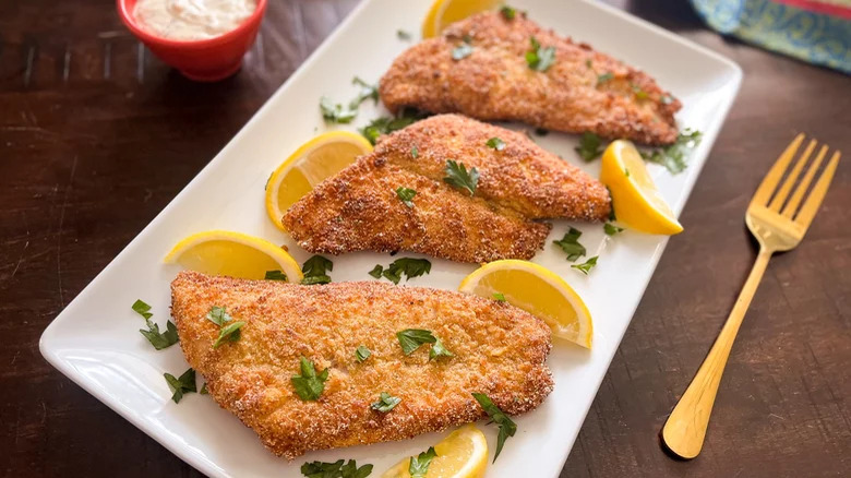 fried cornmeal coated catfish with lemon slices