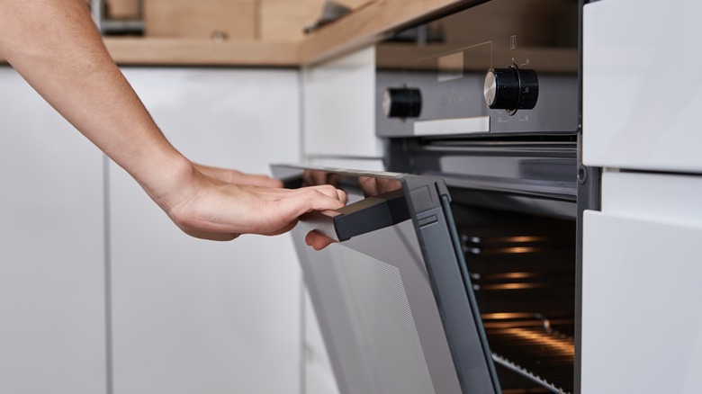 Hands opening oven