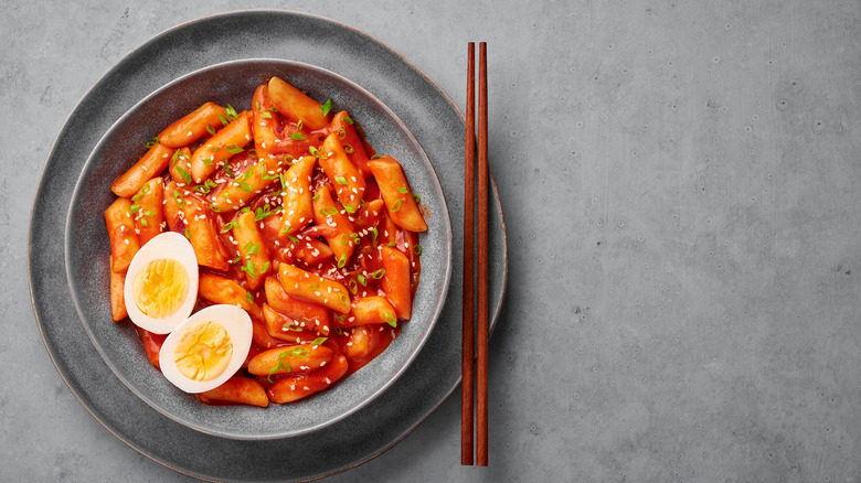 bowl of Tteokbokki with hard boiled eggs and chopsticks 