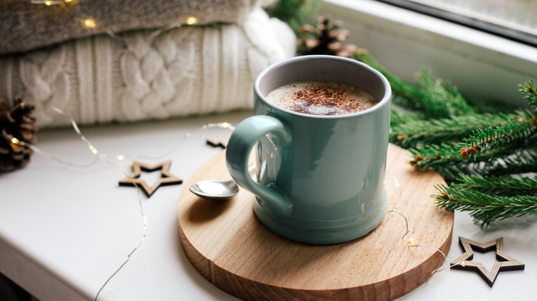 Mug of hot chocolate with pine tree and star decorations