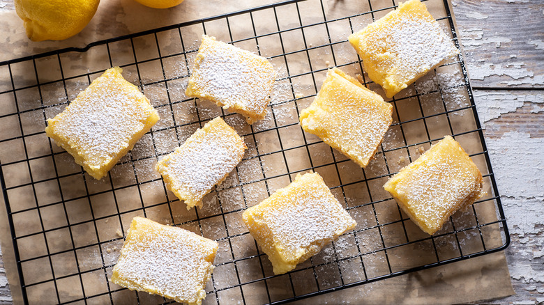 Lemon bars on drying rack with whole lemons