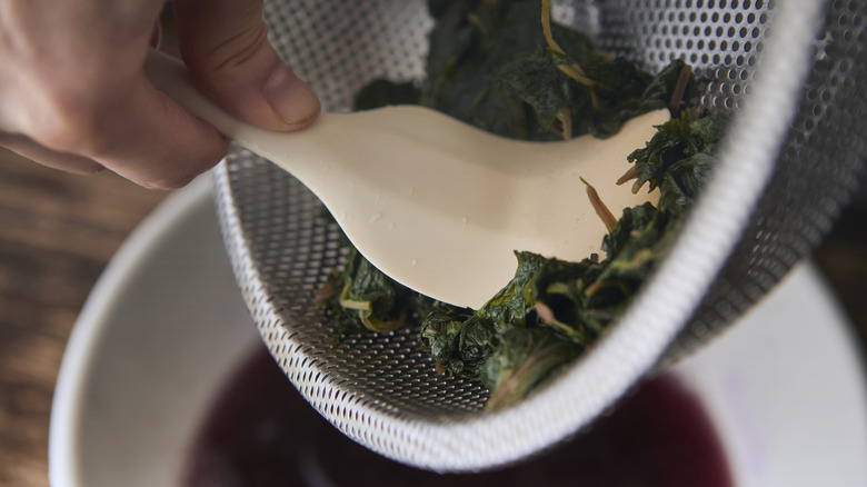 Straining cooking liquid out of spinach