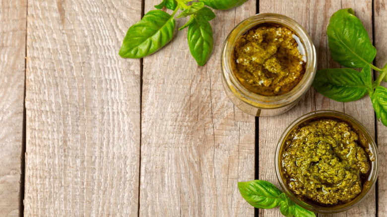 Jars of pesto with fresh basil