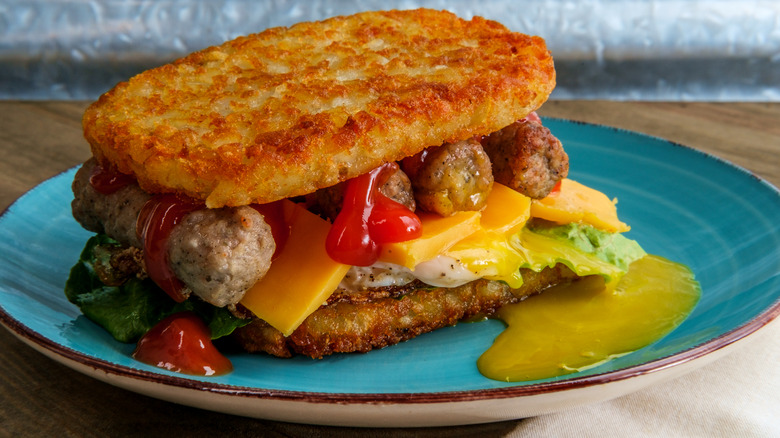 Hash brown sandwich with sausages, egg, and cheese