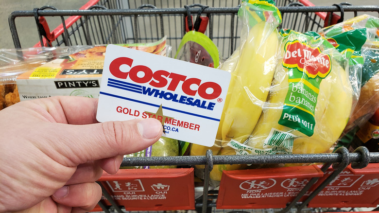 holding Costco membership card over cart