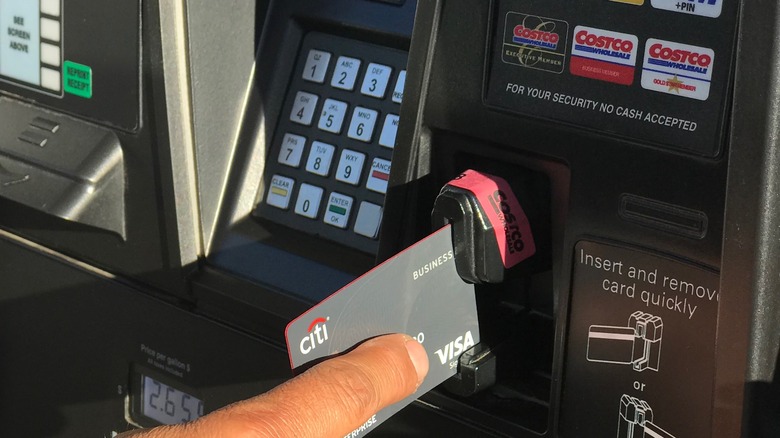 Person using Costco credit card at gas pump