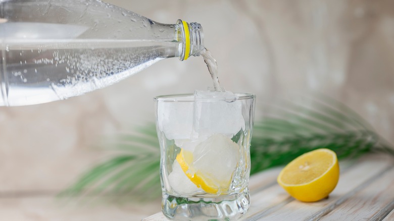 pouring tonic water into a gin 